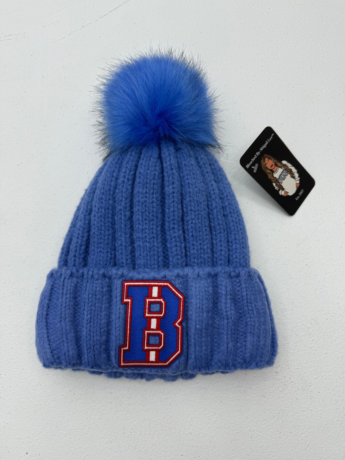 Buffalo "B" Winter Pom-Pom Hat – Cozy winter hat with a Buffalo "B" design and pom-pom on top, perfect for game days and cold weather.