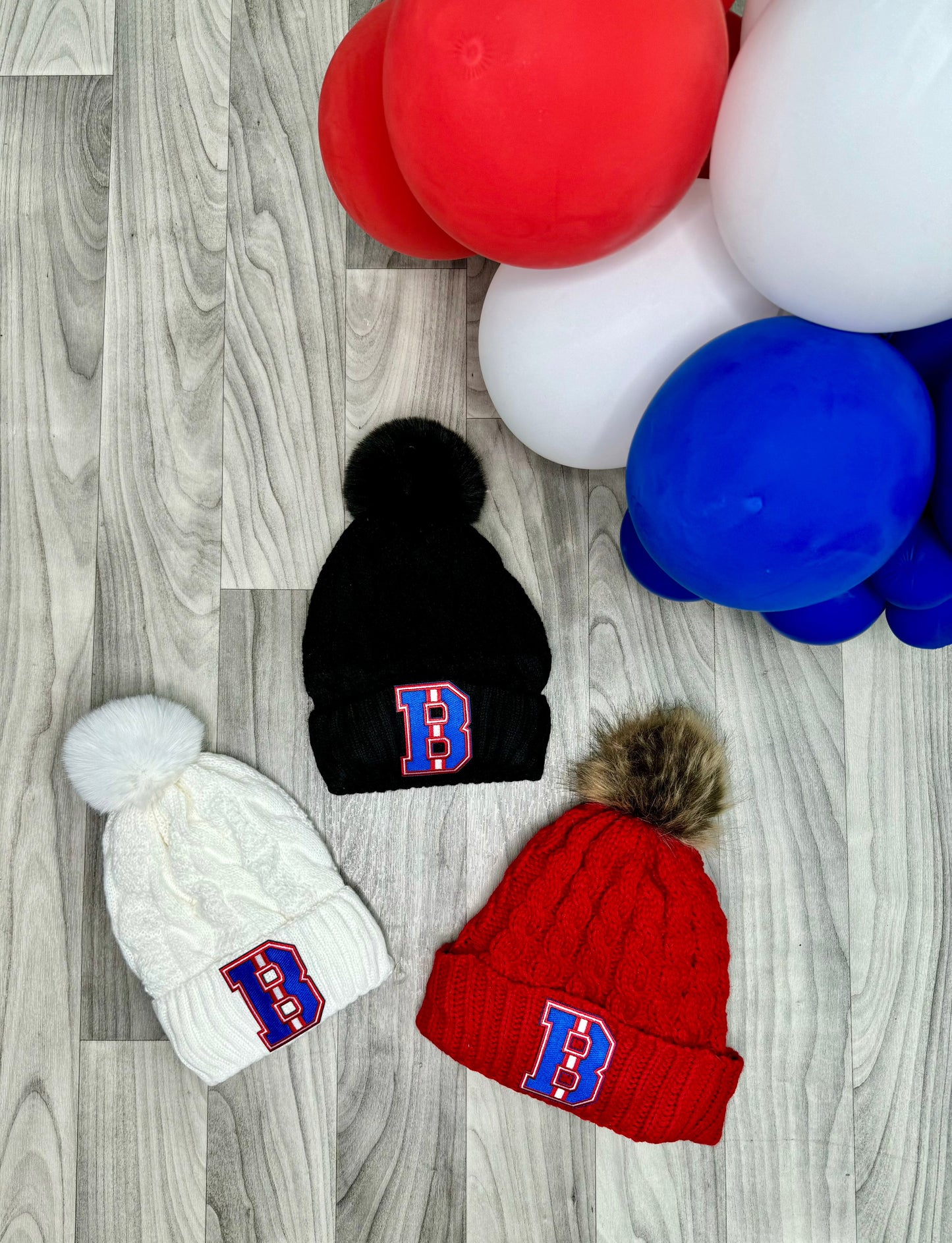 Buffalo "B" Winter Pom-Pom Hat – Cozy winter hat with a Buffalo "B" design and pom-pom on top, perfect for game days and cold weather.