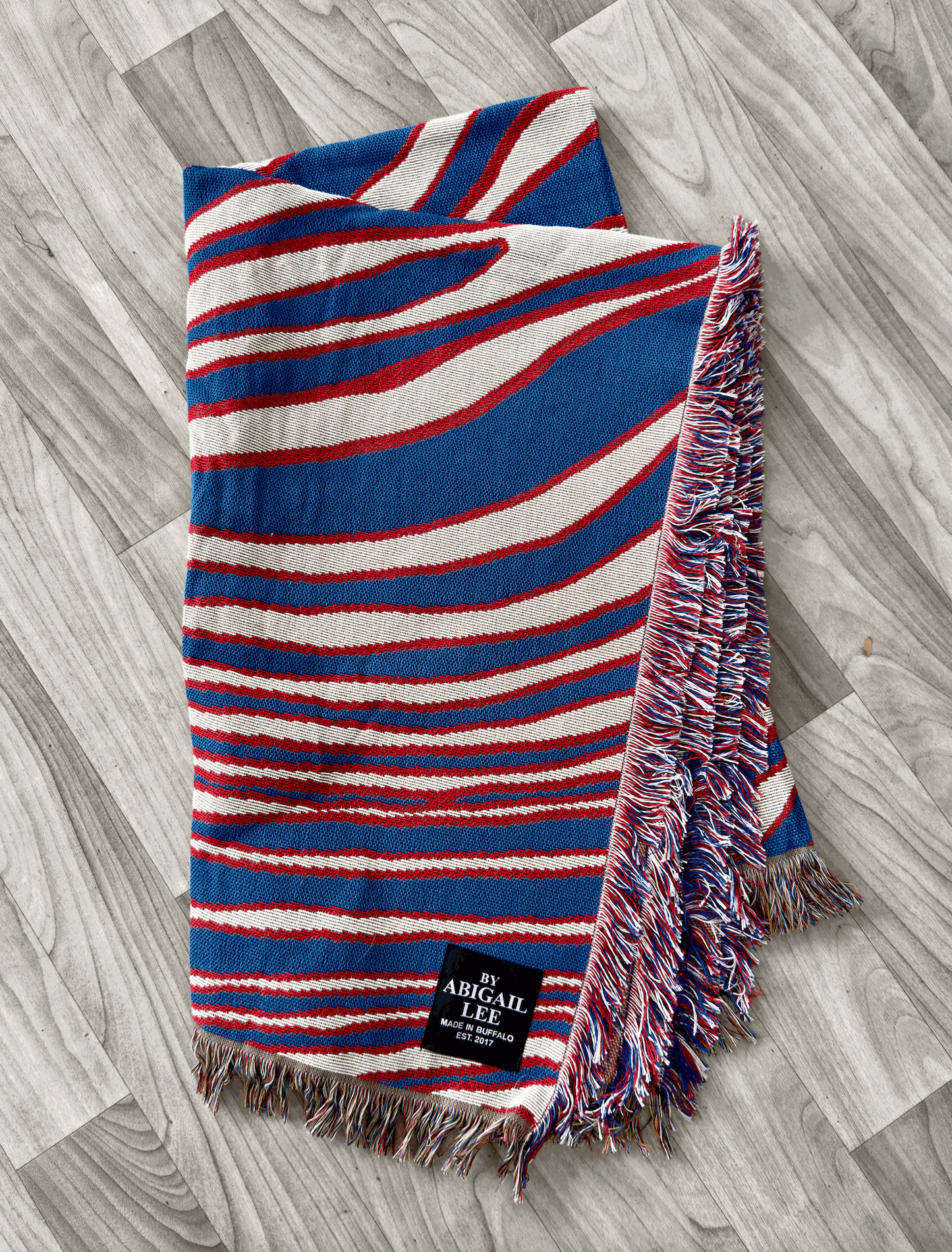 Buffalo Royalty Blanket draped on a couch with rustic decor background