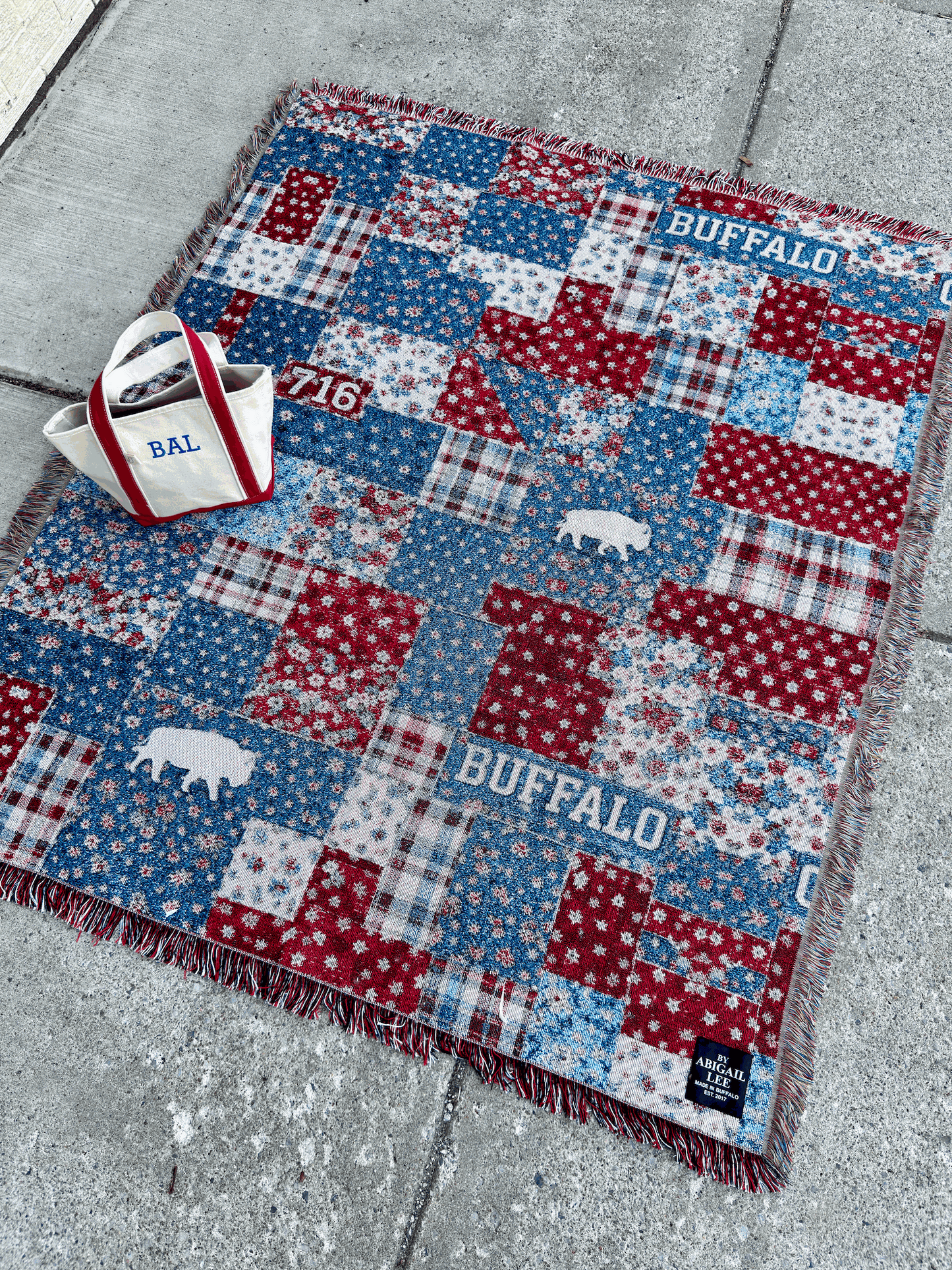 Buffalo tapestry blanket with vintage patchwork design in red, white, and blue featuring Buffalo silhouettes and fringe edges