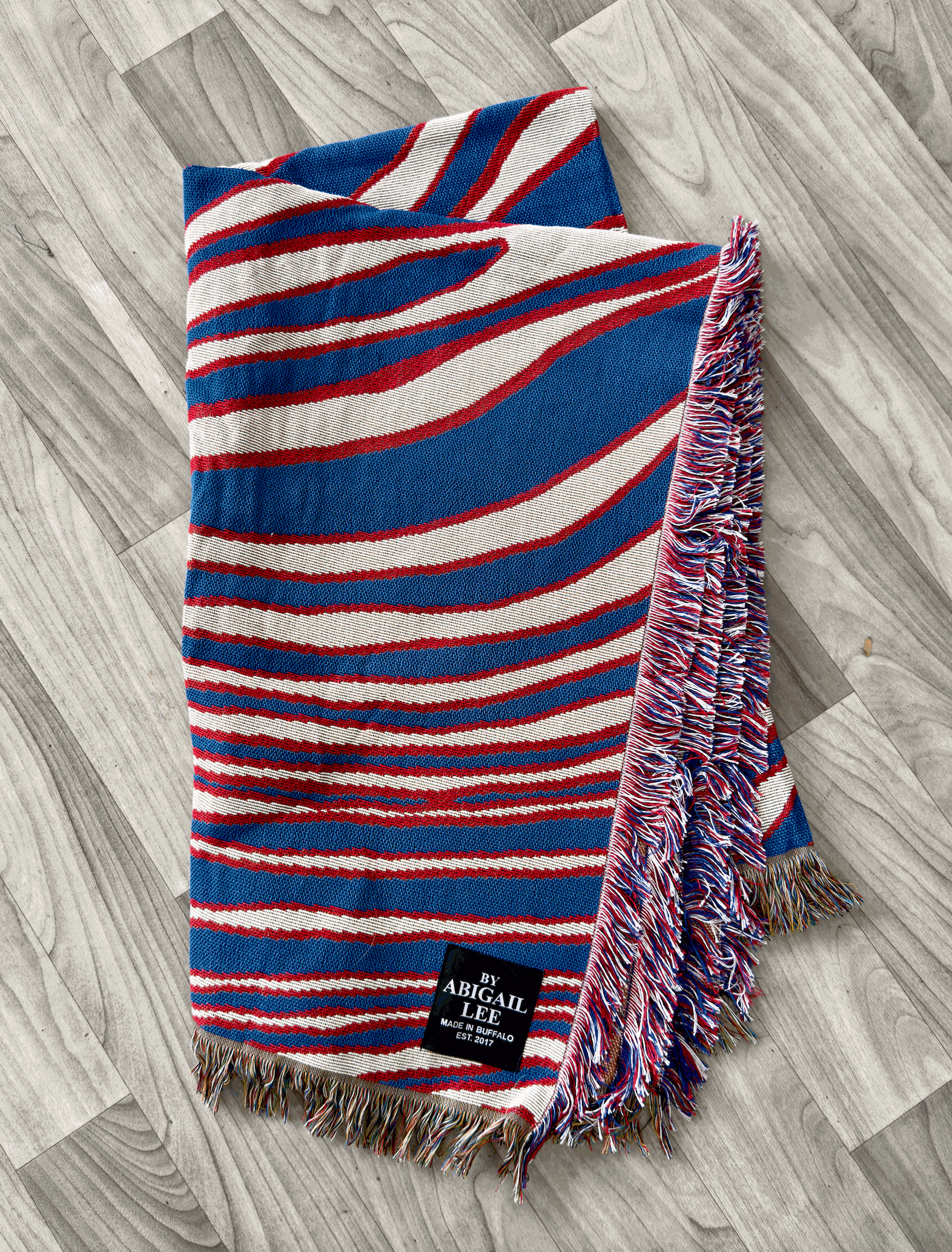 Buffalo Royalty Blanket draped on a couch with rustic decor background