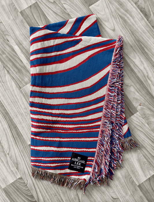 Buffalo Royalty Blanket draped on a couch with rustic decor background